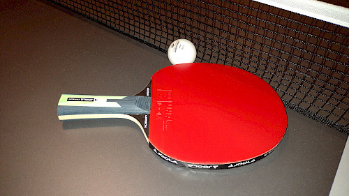 Der JOOLA Tischtennisschläger MEGA CARBON auf Tischtennisplatte mit Ball
