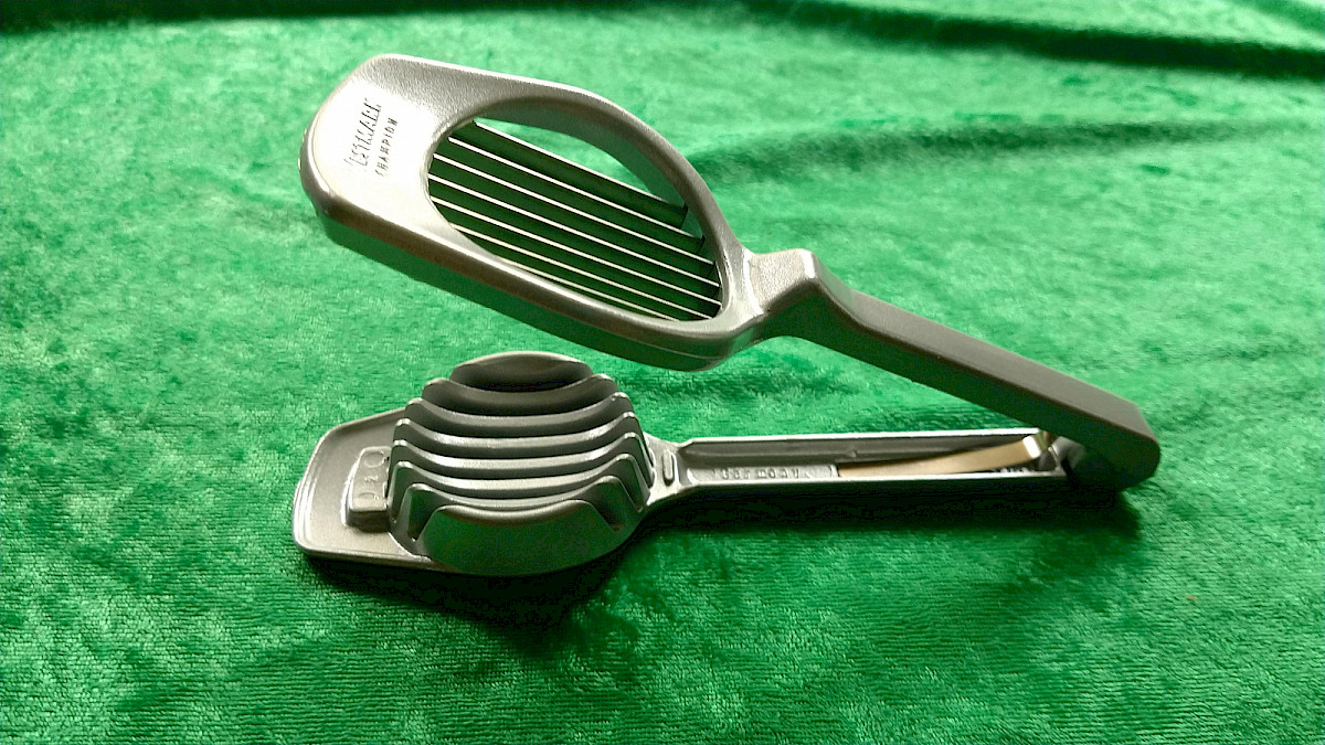 Image description: The opened Westmark Multipurpose Slicer is shown from the side, displaying its sharp stainless steel blades and sturdy aluminum construction.