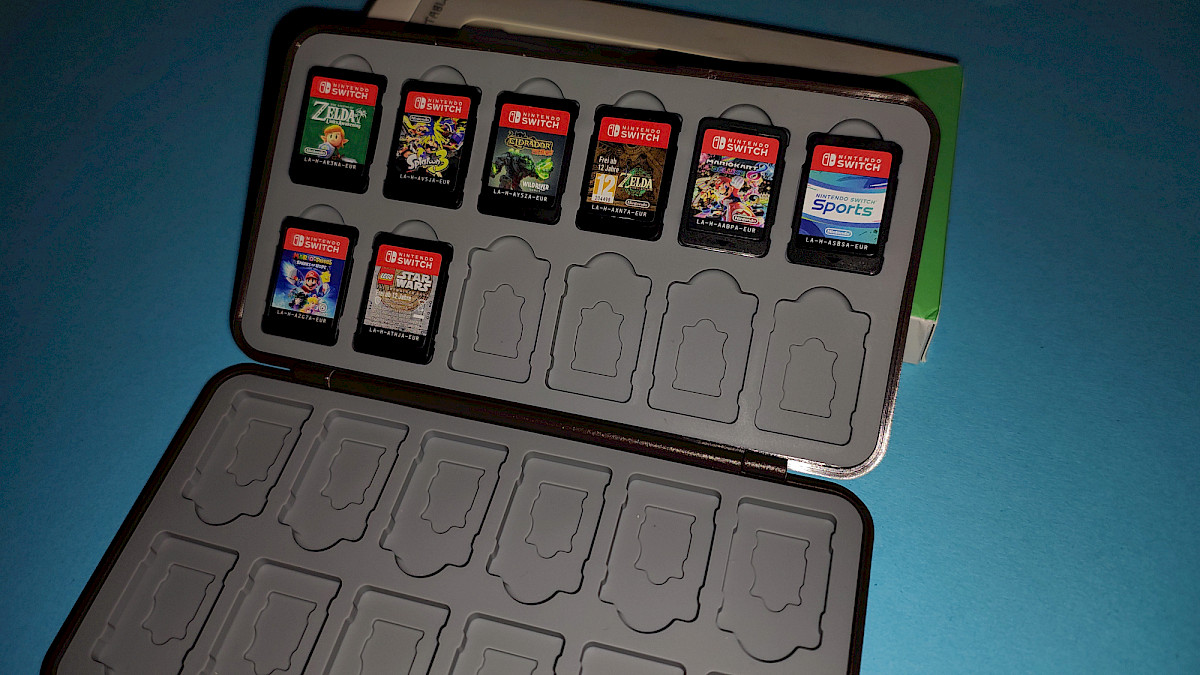 Die Praxisansicht zeigt 8 eingesetzte Nintendo Switch Spiele (u.a. Zelda, Mario Kart, Lego Star Wars) und demonstriert die tatsächliche Nutzung der Aufbewahrungsbox.