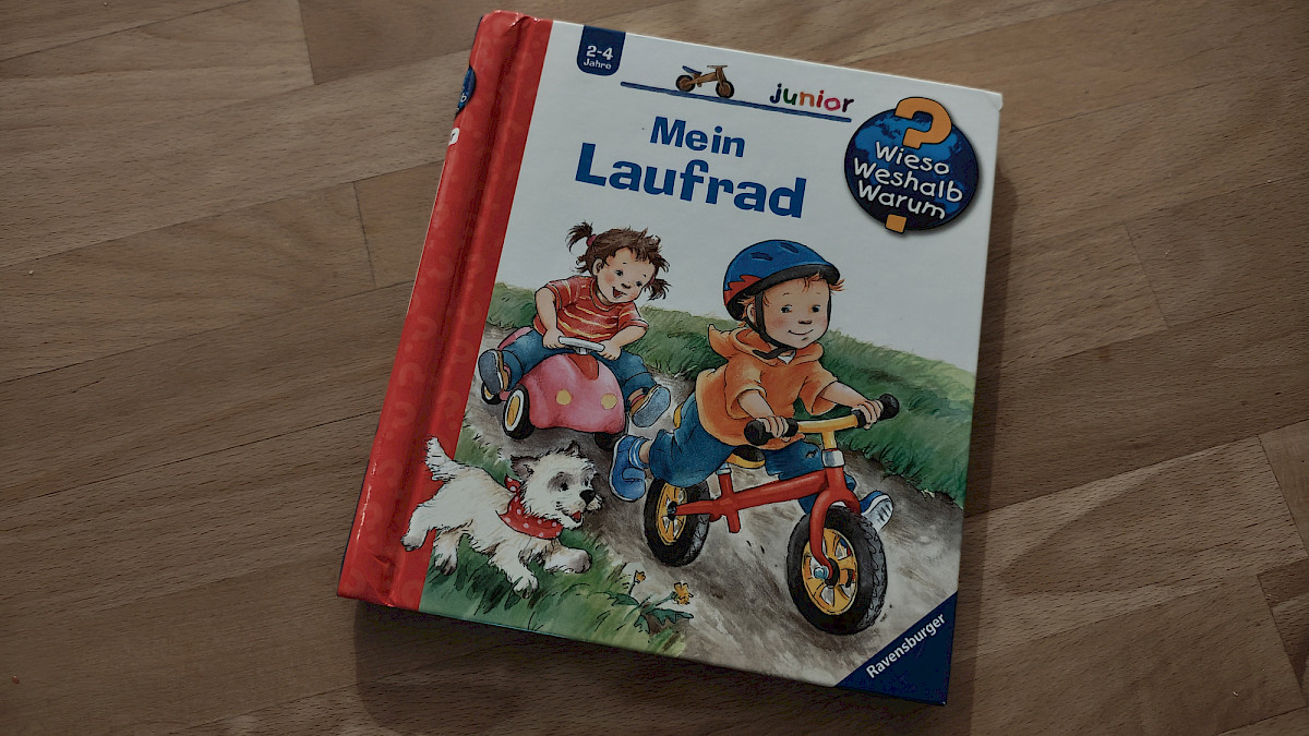 Das Ravensburger Sachbuch Mein Laufrad zeigt auf dem Cover Paul mit seinem roten Laufrad, begleitet von seiner Schwester und dem Familienhund.