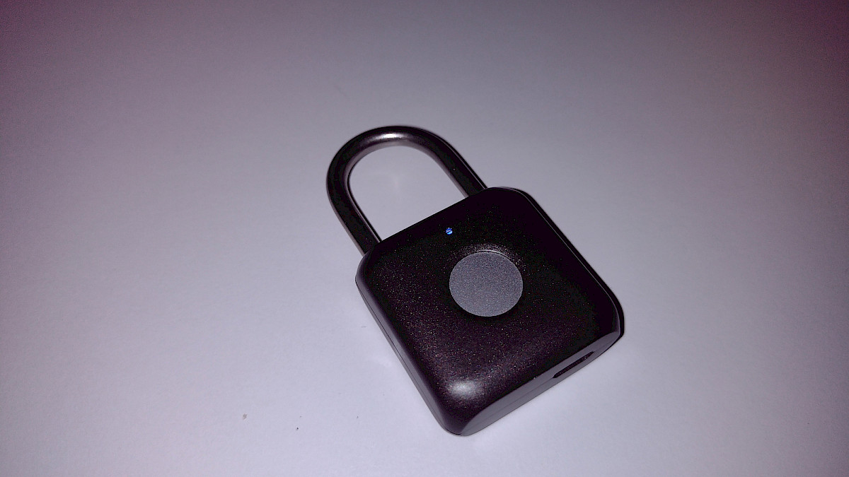 Das Smart Padlock zeigt seine kompakte Bauform mit dem zentral platzierten runden Fingerabdruck-Sensor.