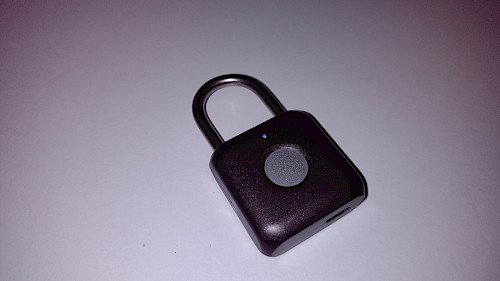 Das Smart Padlock zeigt seine kompakte Bauform mit dem zentral platzierten runden Fingerabdruck-Sensor.